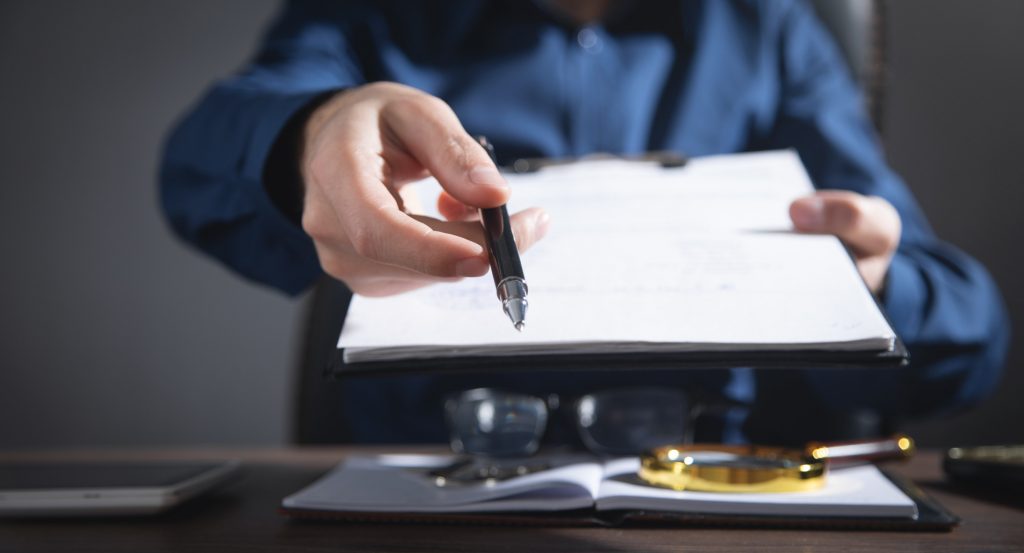 Businessman giving business contract and pen.