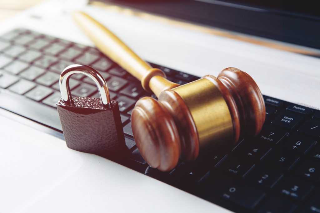 Laptop with a hammer and lock on the table.