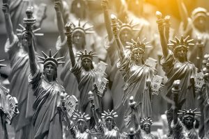 Row with generic Statue of Liberty statues sold as souvenirs in a NYC shop — selective focus.