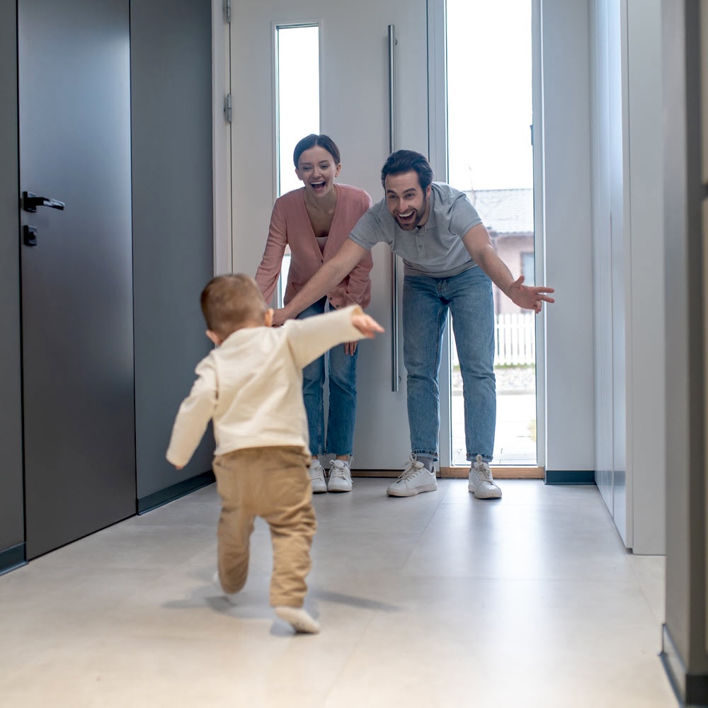 Family joyfully reuniting, including a toddler rushing to meet his father after his father was released from jail.